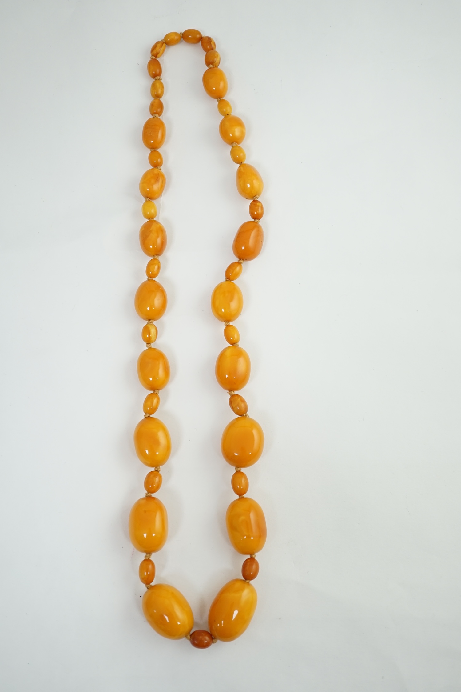 A single strand graduated oval amber bead necklace, with small amber bead spacers